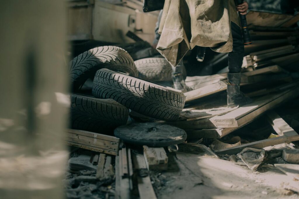 A gritty indoor shot of scattered tires and debris in an abandoned warehouse.