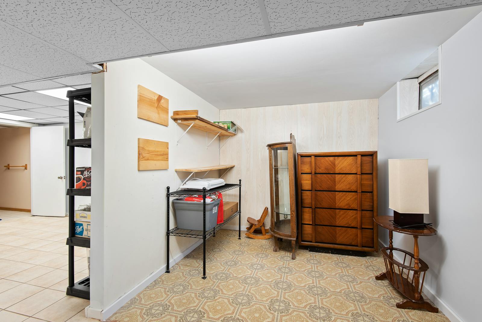 A cozy retro basement with wooden furniture and storage shelves.